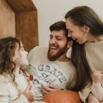 Happy family enjoying quality time with their children indoors, sharing laughter and joy.