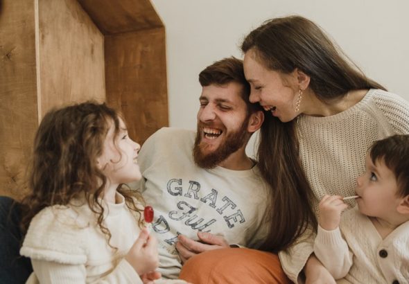 Happy family enjoying quality time with their children indoors, sharing laughter and joy.
